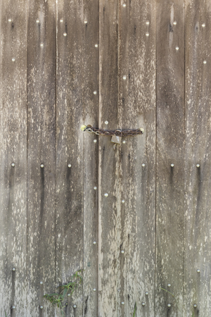 old barn door made of wood locked with padlock and chain - verticalの写真素材