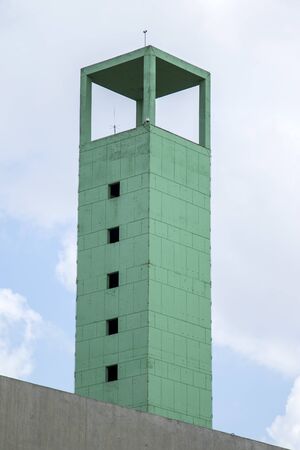 green square geometric concrete tower with cloudy sky as backgroundの写真素材