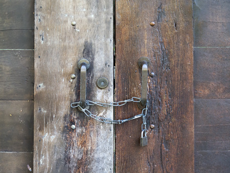 old closed wooden door with chain and padlockの写真素材