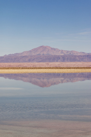 mountain reflected in salt flats lake in atacama desertの写真素材