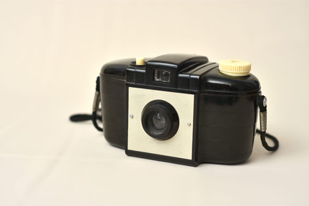 Old photographic camera on beige infinite background