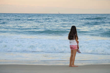 Young man looking at the horizon on the beach in Brazilの写真素材