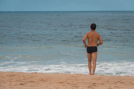 Male bather running from the beach towards the sea in Rio de Janeiroの写真素材