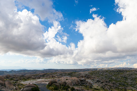 Rocky plain with deep blue sky and very large clouds on a summer day