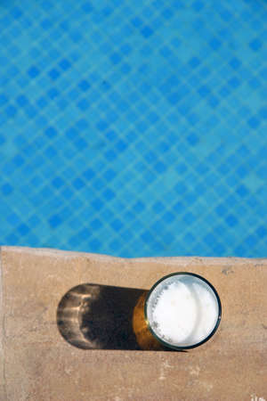 Glass of Beer on the edge poolの写真素材