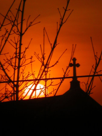 sunset behind a church and crossの写真素材