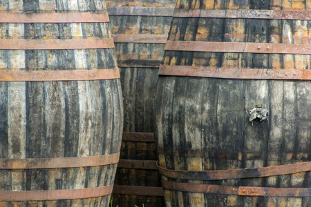 Three old barrels making a background with tones of black, grey and orangeの写真素材