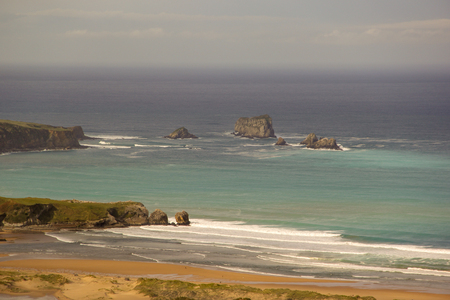 Great beach and cliffs with green tones in the seaの写真素材