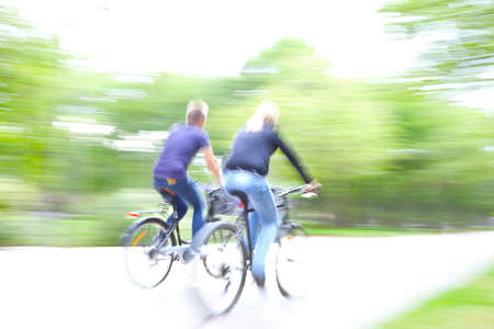 Riding bike on morning light through the parkの写真素材
