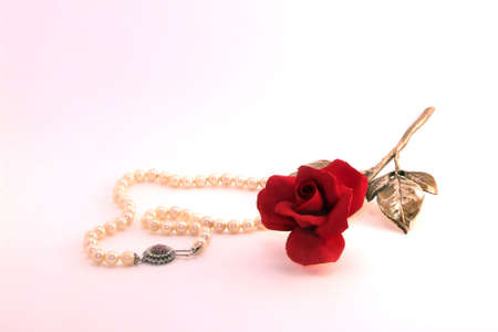 A pearls necklace and a red roseの写真素材