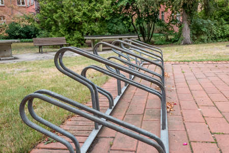 Berlin, Berlin/Germany - 19.07.2019: A metal bicycle stand for several bicycles on a path in front of a lawn with parking spaces of different heights.の写真素材