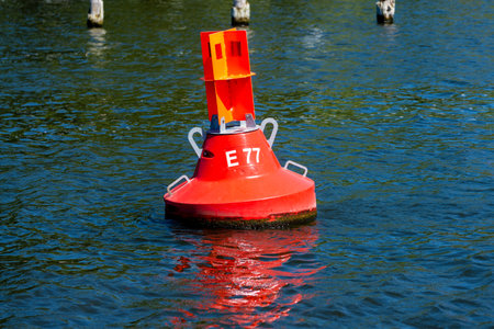 A red buoy, which indicates to which side the boats have to sail to stay in the fairway.のeditorial素材