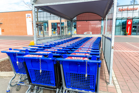 Potsdam, Brandenburg/Germany - 24.03.2019: Three rows of new shopping trolleys on the parking lot of Rewe in Potsdam in Blauのeditorial素材