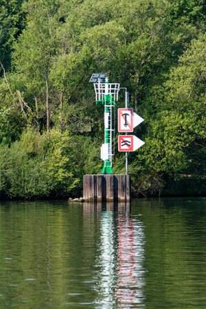 Signposting on a waterway in Berlin-Brandenburg, which says that you should avoid waves to the right and anchor is forbidden. A green-white buoy indicates that there is a water obstacle.のeditorial素材