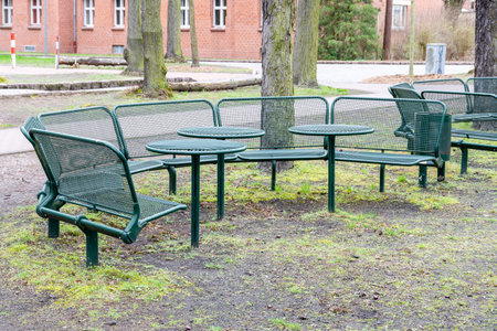 Berlin, Berlin/Germany - 24.03.2019: A seat made of steel, round arranged with tables and benches in greenのeditorial素材
