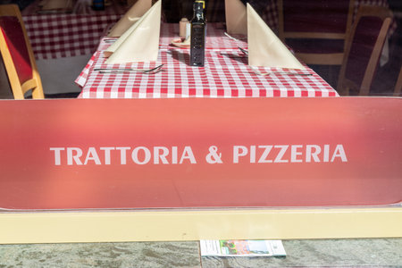 Potsdam, Brandenburg/Germany - 24.03.2019: The window of an Italian restaurant from the outside with a view of a table and checkered table linen and a bottle of wine.のeditorial素材