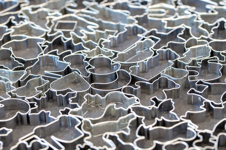 Various cookie cutters with animal motifs for cookies and cookies on a gray background of stainless steelの写真素材