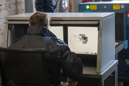 Roma, Lazio - Italy - 11-23-2022: A person looks at the monitor of an X-ray scanner as part of a...