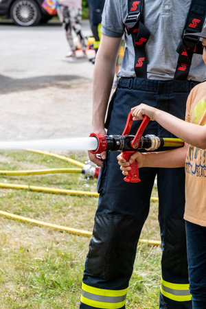 Templin, Brandenburg - Germany - 06-09-2022: Child experiences being a firefighter under guidance at a local safety demonstrationのeditorial素材