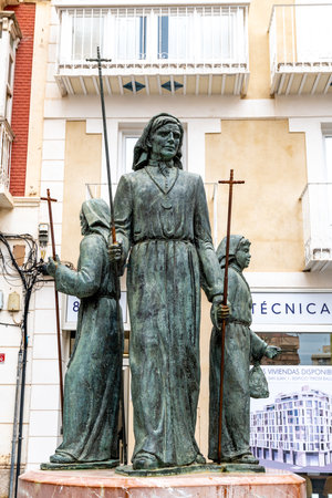Cartagena, Murcia - Spain - 01-16-2024: Bronze sculpture of three Nazarenes, symbols of Cartagena's Holy Week, standing in urban surroundingsのeditorial素材