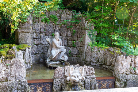Salzburg, Salzburg - Austria - 06-18-2021: Statue of Neptune in a moss-covered stone grotto at...
