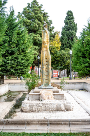 Tarragona, Tarragona - Spain - 10-31-2023: Tall, stylized sculpture of a fishlike human amidst greenery in Oliva's urban parkのeditorial素材