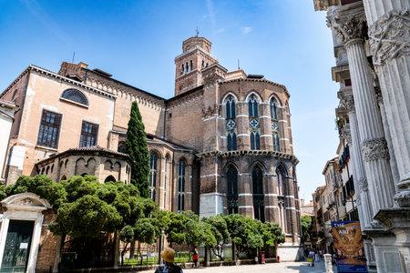 Venice, Veneto - Italy - 06-10-2021: Scene featuring Cathedral Santa Maria Gloriosa dei Frari with columns of Scuola Grande di San Rocco on the right, Venice, Italyのeditorial素材