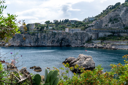Coastal Cliffs and Waterfront Buildings in Taorminaの写真素材