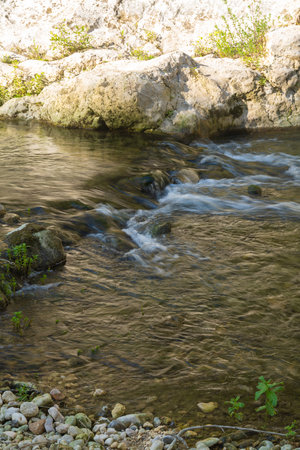 Flowing stream over rocks in Pantalica sunlightの写真素材