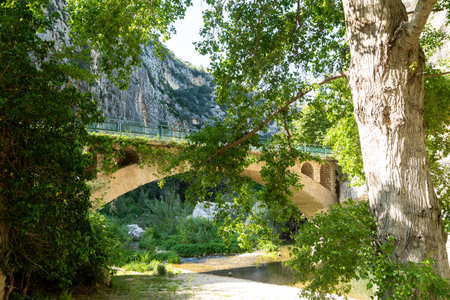 Stone arch bridge crossing river in Pantalica gorgeの写真素材