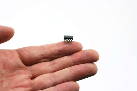 An isolated on hand on a white background holding a micro chip on the finger tip.の写真素材