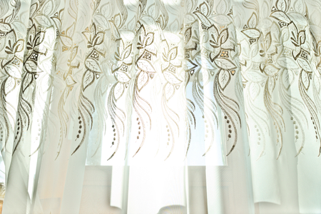 Curtains with a pattern in the hall illuminated by sunshineの写真素材