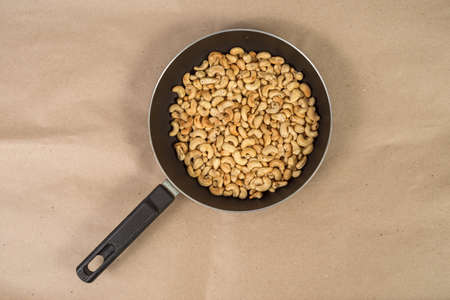 Roasted cashews in frying pan on paperの写真素材