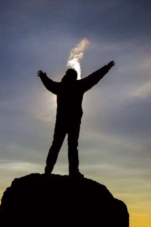 Silhouette of a man on the mountain during sunset. Winter frosty evening.の写真素材
