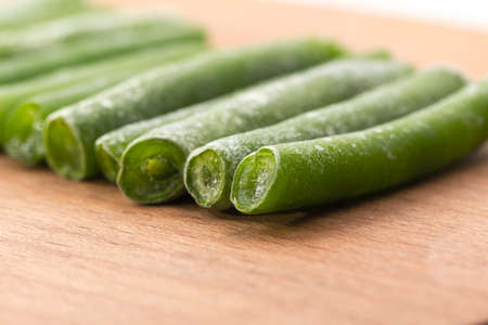 Frozen sticks of asparagus. Wood background. Wood plate.の写真素材