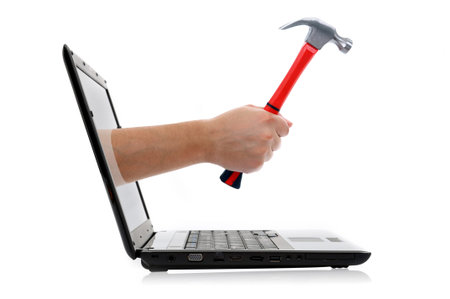 hand with hammer comes from laptop screen on the white backgroundの写真素材