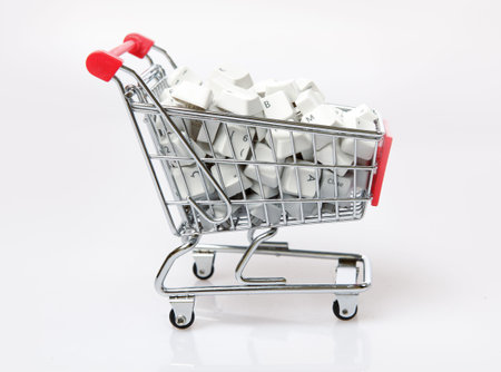 Computer Keys in the shopping cart on the white background. E-commerce concept.