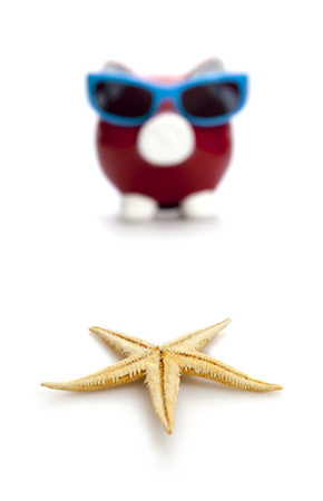 Piggy Bank on beach vacation on the white backgroundの写真素材