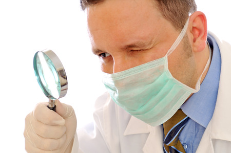 doctor is looking at magnifying glass on the white backgroundの写真素材