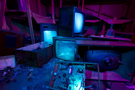 Light painted abandoned cinema studio. 3 crashed TV sets still shining. Halloween party backgroundの写真素材