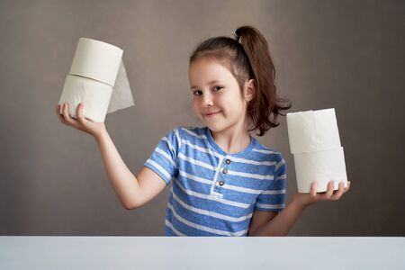 beautiful girl sitting at the table and toilet paper in short supplyの写真素材