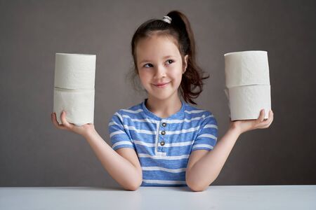 beautiful girl sitting at the table and toilet paper in short supplyの写真素材