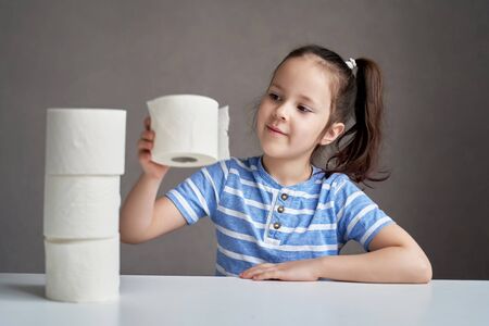 beautiful girl sitting at the table and toilet paper in short supplyの写真素材
