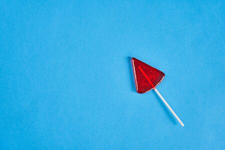 Two red lollipops on white sticks. In the right down corner on the blue background. Red and blue, lollipops minimalismの写真素材