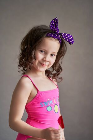 Sweet pretty young woman with lollipop over pink background.の写真素材