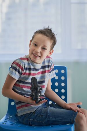 Close-up of little boy playing video games lying on the floorの写真素材