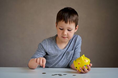 the child collects money in a piggy Bank.の写真素材