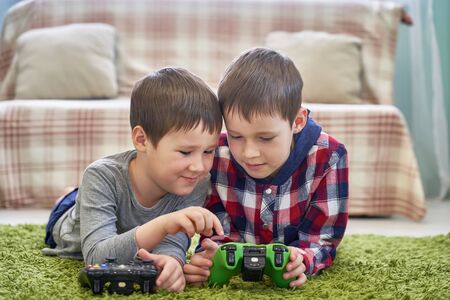 two small boys playing video game in quarantine in homeの写真素材