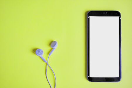 smartphone and headphones on a bright background.の写真素材