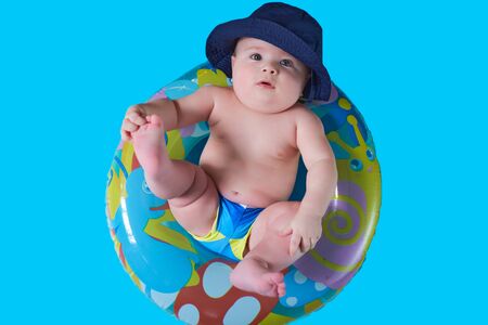 a funny little kid in a Panama hat sits in a bathing circle.の写真素材